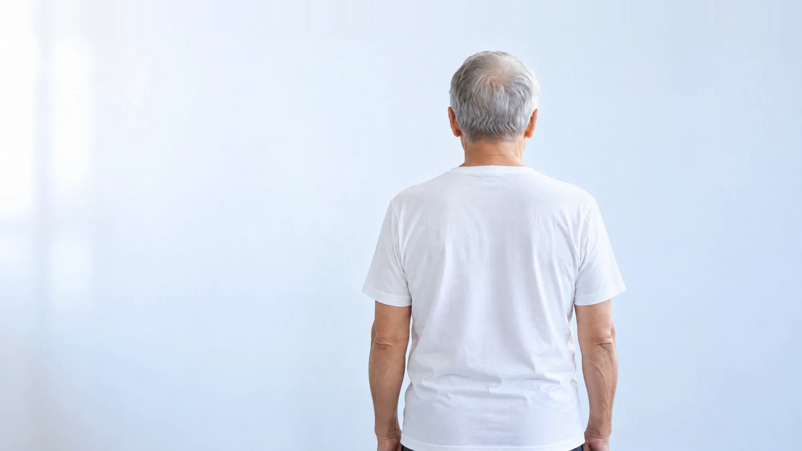 An older man seen from behind, shown as a figure made of thousands of dots with research areas marked on the body