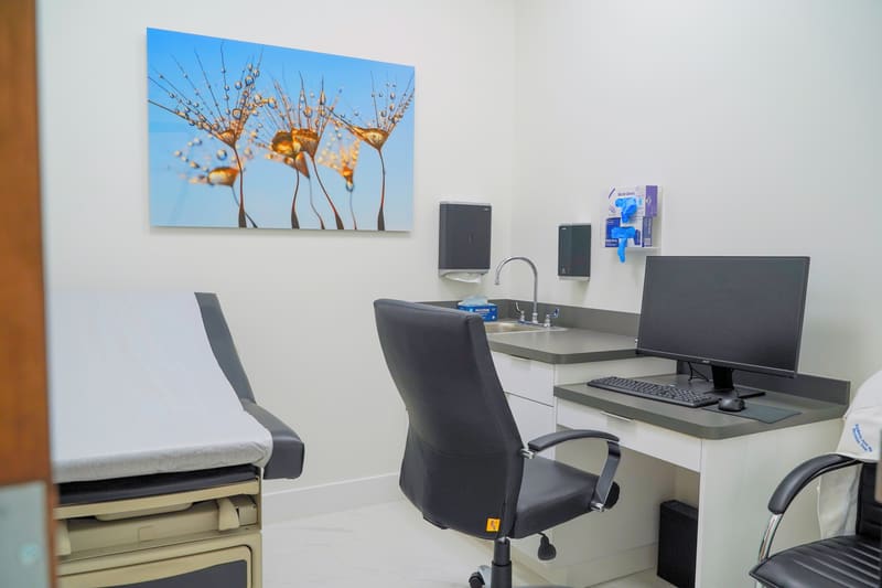 Exam room with exam table, desk and computer